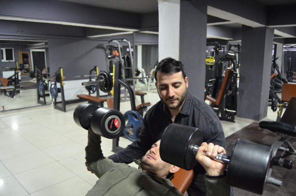 Dumbbell press antrenmanı, eğitmen desteğiyle